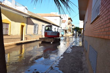 Una máquina retira lodo de las calles próximas a la playa de Los Alcázares
