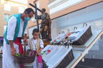 Un vecino deposita la ofrenda junto a su hijo en la plaza de San Pedro