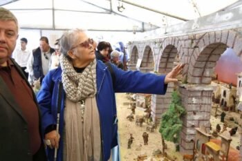 Una mujer con baja visión toca el Belén de La Aparecida