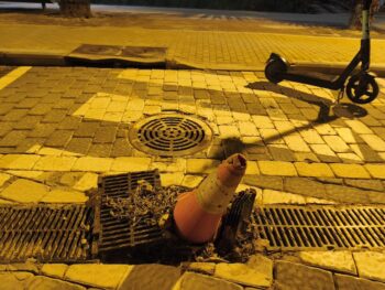 Imagen de un cono de tráfico en una calle afectada por barro y suciedad