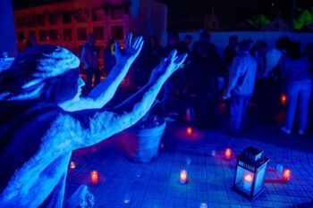 Escena del evento Don Juan Tenorio en el cementerio de San Javier con velas y figurantes.