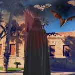 Persona con capa en un ambiente de Halloween con murciélagos