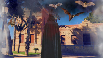 Persona con capa en un ambiente de Halloween con murciélagos