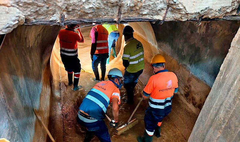 Trabajadores limpiando un canal de abastecimiento afectado por barro