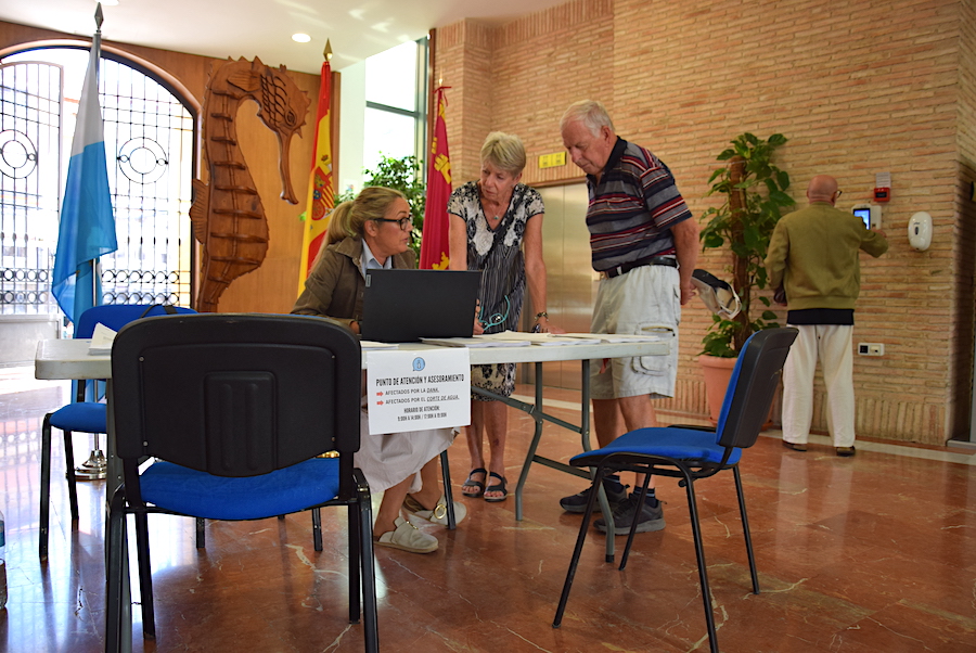 Una pareja de residentes de la urbanización Oasis se informa en el punto de recogida de reclamaciones por gastos de la dana y el agua en Los Alcázares
