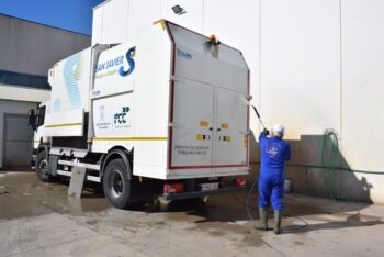Trabajador limpiando un camión de recogida de basuras en San Javier