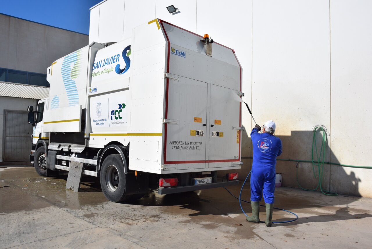 Trabajador limpiando un camión de recogida de basuras en San Javier