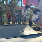 Niño patinando en el skatepark Parque Almansa con espectadores al fondo.