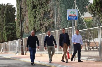 Cuatro hombres caminando en la Avenida del Taibilla con señal de atención niños.