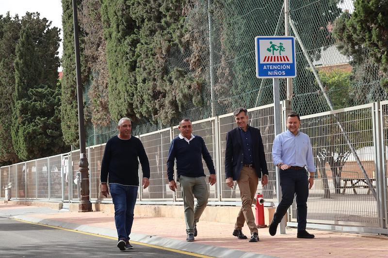 Cuatro hombres caminando en la Avenida del Taibilla con señal de atención niños.