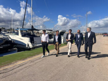 Grupo de personas caminando junto a embarcaciones en el puerto de Mar de Cristal