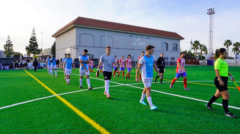 Jugadores ingresando al campo de fútbol renovado en La Torre