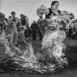 Participantes en una bienal fotográfica saltando sobre fuego en Cartagena