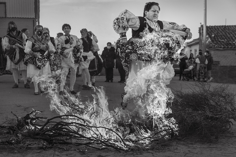 Participantes en una bienal fotográfica saltando sobre fuego en Cartagena
