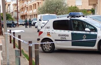 Escena del crimen en Lo Pagán con un cuerpo cubierto y vehículos de la Guardia Civil.