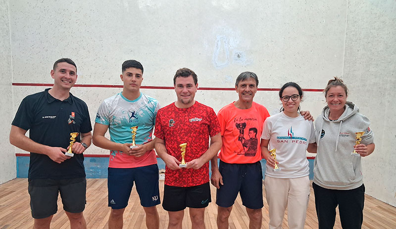 Ganadores del IV Campeonato Regional de Squash mostrando sus trofeos en el centro deportivo.