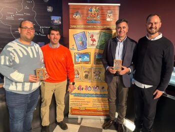 Presentación del juego de mesa Tesoros del Mar Menor con cuatro personas y un cartel