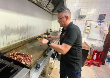 Cocinero preparando gambas en la plancha del bar El Quiosco