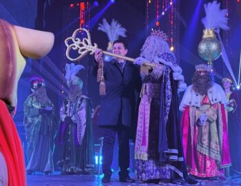 Los Reyes Magos en un evento con luces y disfraces coloridos