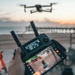 Controlador de drone en la playa al atardecer