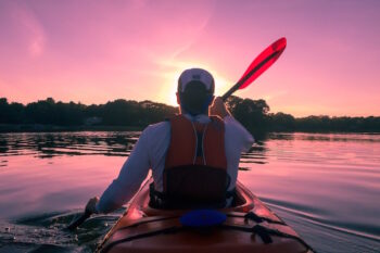 Persona remando en kayak durante un atardecer en el Mar Menor