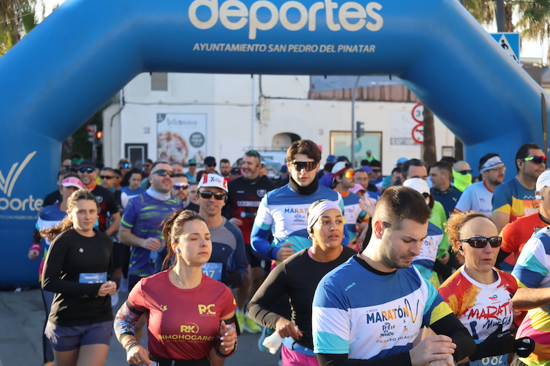 Atletas corriendo en la Media Maratón de San Pedro del Pinatar bajo un arco de meta.