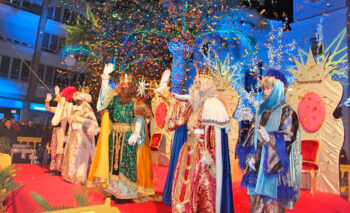 Los Reyes Magos saludando a los asistentes en un evento navideño
