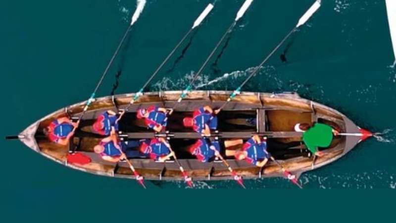 Equipo de remo tradicional compitiendo en el mar