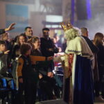 Reyes Magos interactuando con niños en un evento bajo techo