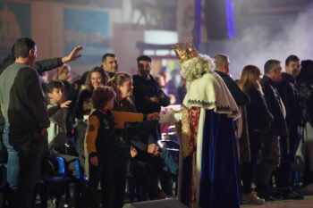 Reyes Magos interactuando con niños en un evento bajo techo