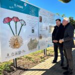 Dos hombres observando un panel informativo sobre rutas de peregrinación en Torre Pacheco.
