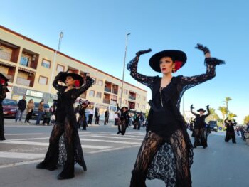 Bailarinas vestidas de negro con flores en el cabello durante el Carnaval de Los Alcázares