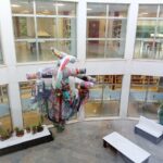 Vista del patio interior de la biblioteca de San Javier con arte y plantas.
