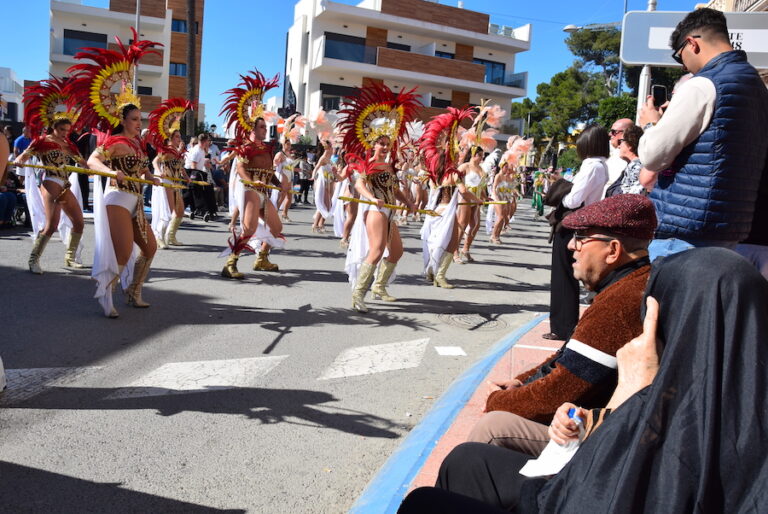 Desfile de carnaval en La Ribera con bailarinas y trajes coloridos