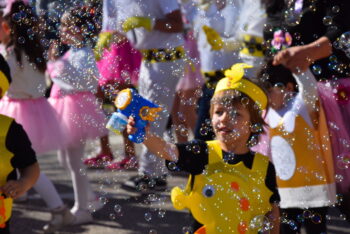 Niño disfrazado en el Carnaval de La Ribera jugando con burbujas