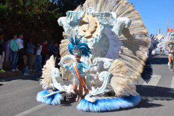 Niña con traje de carnaval y plumas en el desfile de La Ribera