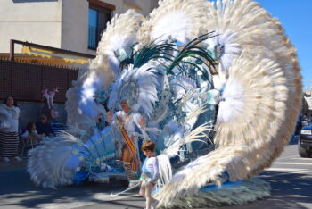 Desfile de carnaval con reina y niño en trajes brillantes