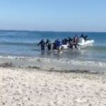 Grupo de personas desembarcando de una patera en la playa de La Torre Derribada