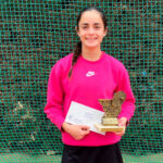 Estrella Pérez sosteniendo un trofeo tras ganar un torneo de tenis