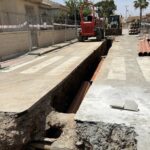 Obras de redes separativas en una calle con maquinaria y tuberías