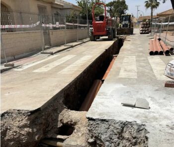 Obras de redes separativas en una calle con maquinaria y tuberías