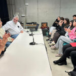 Estudiantes aplaudiendo durante una ponencia sobre investigación histórica.