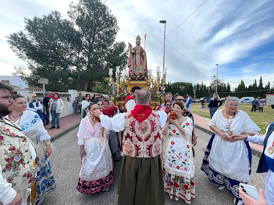 Celebración de la romería de San Blas con romeros y el santo en un trono dorado.