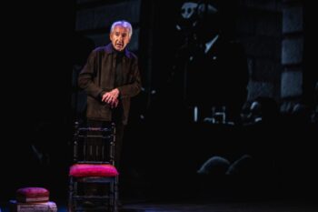 Sacristán actuando en el escenario con una silla y un baúl