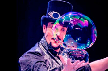 Artista mostrando burbujas mágicas en un espectáculo familiar