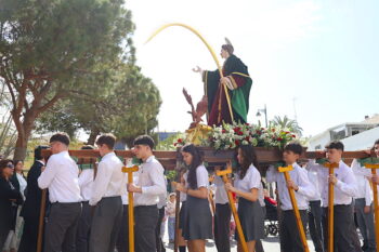 Estudiantes portando el trono de San Juan Evangelista en procesión