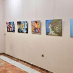 Persona observando obras de arte en una exposición en Los Alcázares