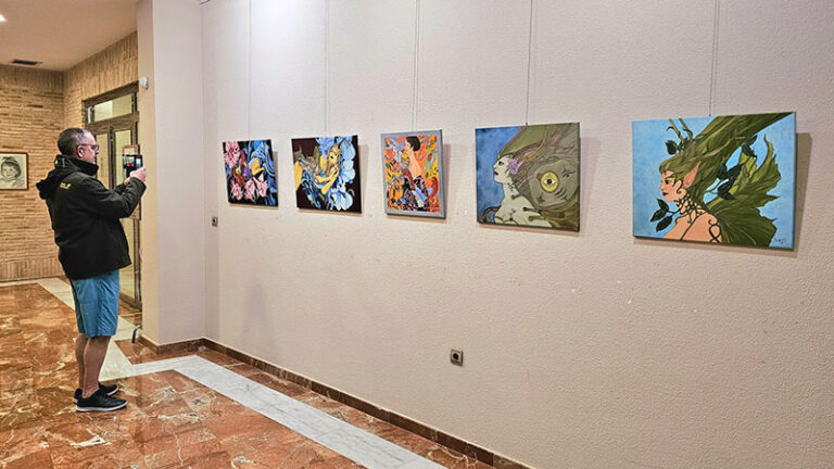 Persona observando obras de arte en una exposición en Los Alcázares