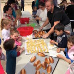 Familias preparando monas en la celebración del Día de la Mona en El Pasico