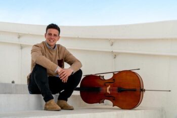 Gabriel Ureña posando junto a su violonchelo en un entorno luminoso